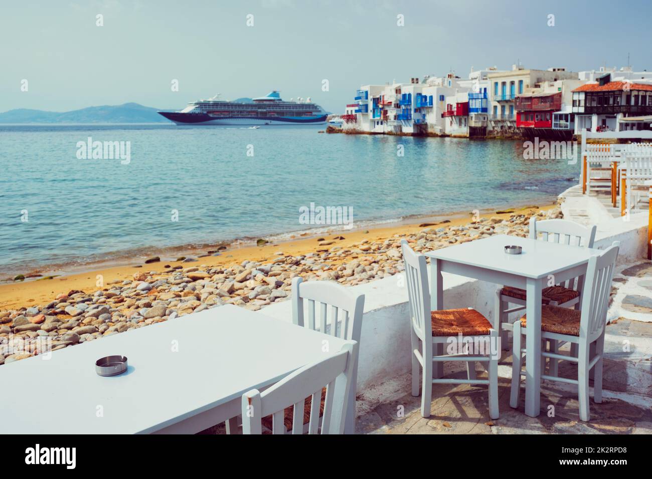 Tavolino da caffè e nave da crociera nel mare Egeo. Chora, isola di Mykonos, Grecia Foto Stock