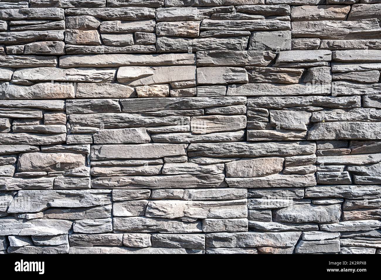 Sfondo fatto di un vecchio muro di pietra grigio naturale Foto Stock