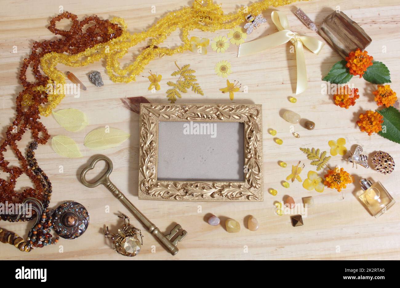 Gioielli e decorazioni gialli e marroni con chiave in ottone vintage e cornice fotografica Foto Stock