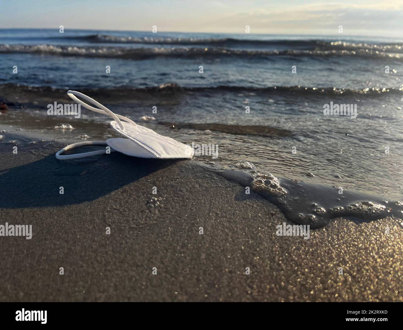 Vacanza in tempi di Covid-19 con una maschera sulla spiaggia Foto Stock