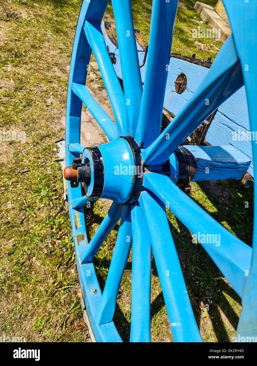 Una vecchia ruota di legno in vernice blu. Foto Stock