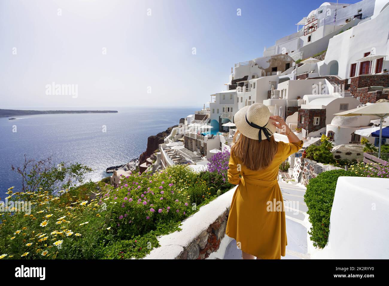Vacanza in Grecia incredibile. Giovane bella ragazza a piedi nel villaggio di Oia sull'isola di Santorini, in Grecia. Grandangolo. Foto Stock
