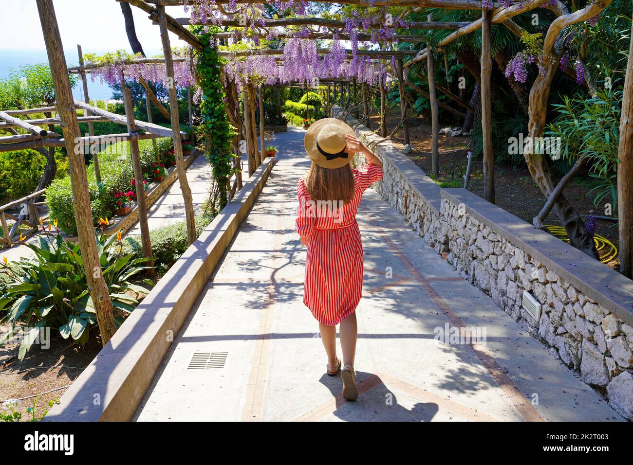 Donna elegante discesa turistica sentiero giardino di Capri, Napoli, Italia Foto Stock