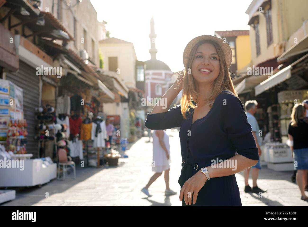 Giovane donna che scopre la città di Rodi al tramonto con la moschea di Suleiman sullo sfondo, la Grecia Foto Stock