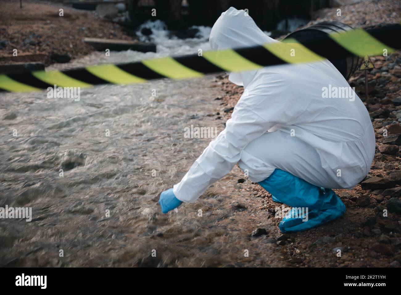 Ecologista che campiona l'acqua dal fiume con una provetta Foto Stock