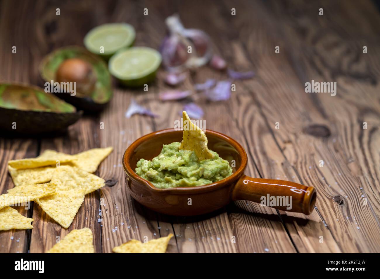 condire con aglio, peperoncino, pepe e succo di lime con nachos di mais Foto Stock