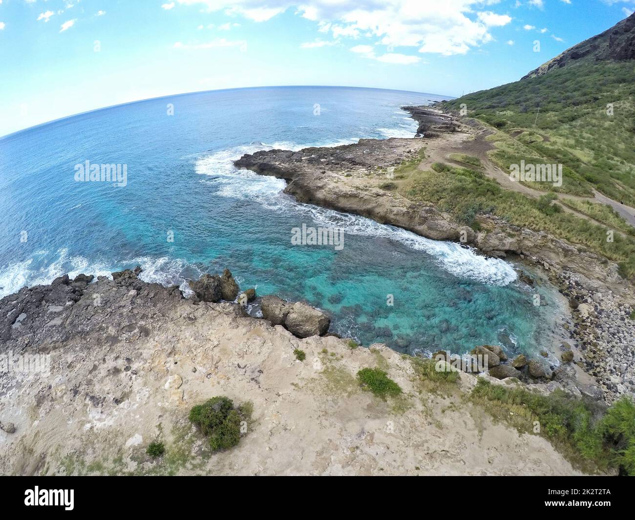 Un mare contro le montagne verdi in una giornata nuvolosa sparata in obiettivo occhio di pesce Foto Stock