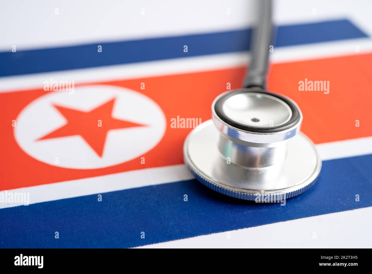 Stetoscopio nero sullo sfondo della bandiera della Corea del Nord, concetto di Business e Finanza. Foto Stock