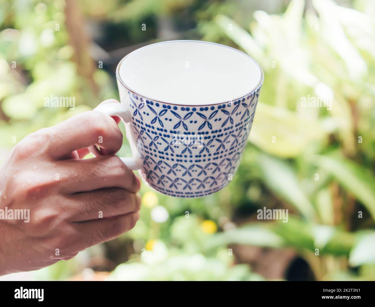 Tazza da caffè vintage bianca e blu asiatico da tenere a mano Foto Stock