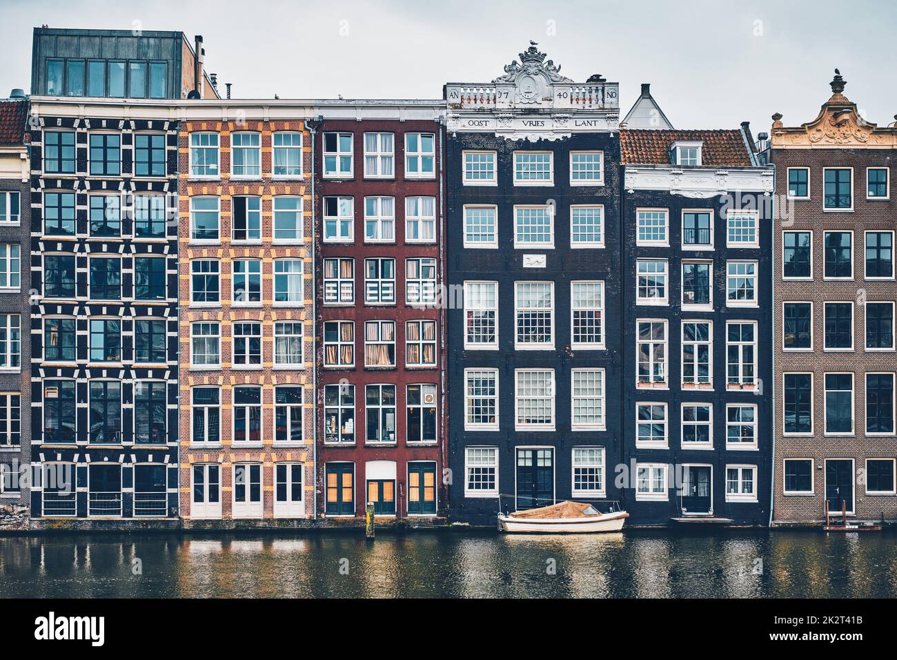 Case e barca sul canale di Amsterdam Damrak con la riflessione. Ams Foto Stock