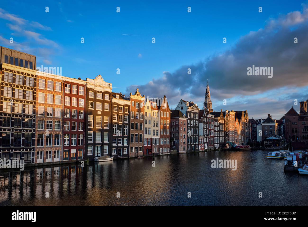 Case e barche turistiche sul canale di Amsterdam molo Damrak in estate. Amsterdam, Paesi Bassi Foto Stock