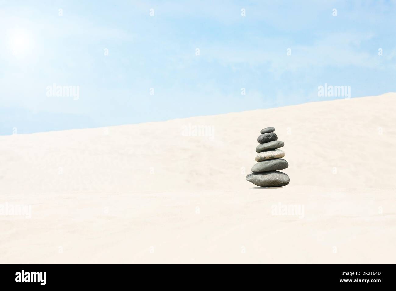 Pietre equilibrato su una spiaggia di ciottoli durante il tramonto. Foto Stock