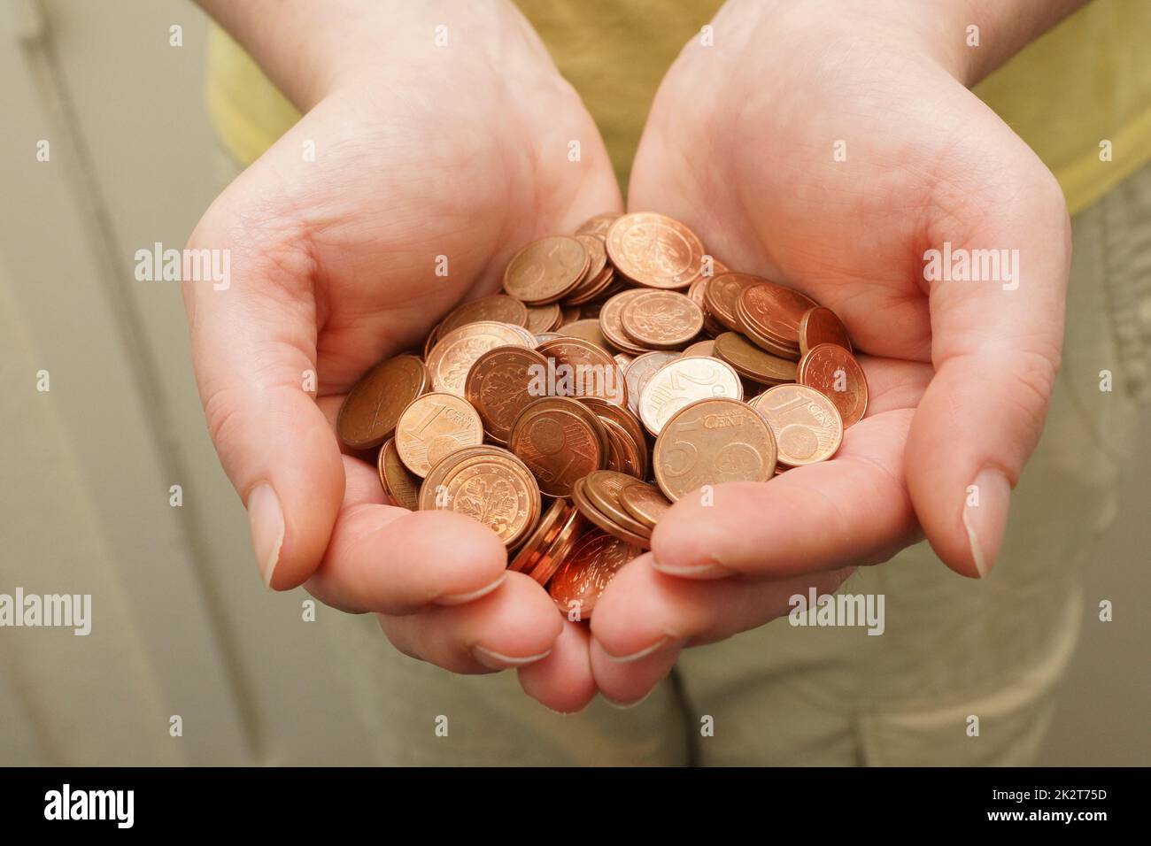 Molte monete da centesimi di euro in mano di donna Foto Stock