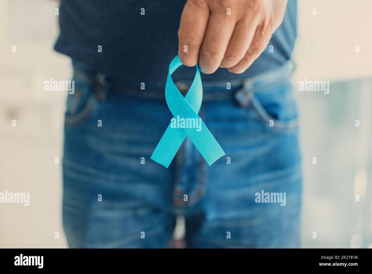 Uomo anziano che tiene un nastro blu di consapevolezza del cancro Foto Stock