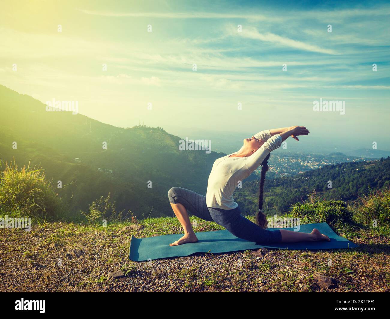 Montare sportivo donna le pratiche yoga Anjaneyasana in montagna Foto Stock