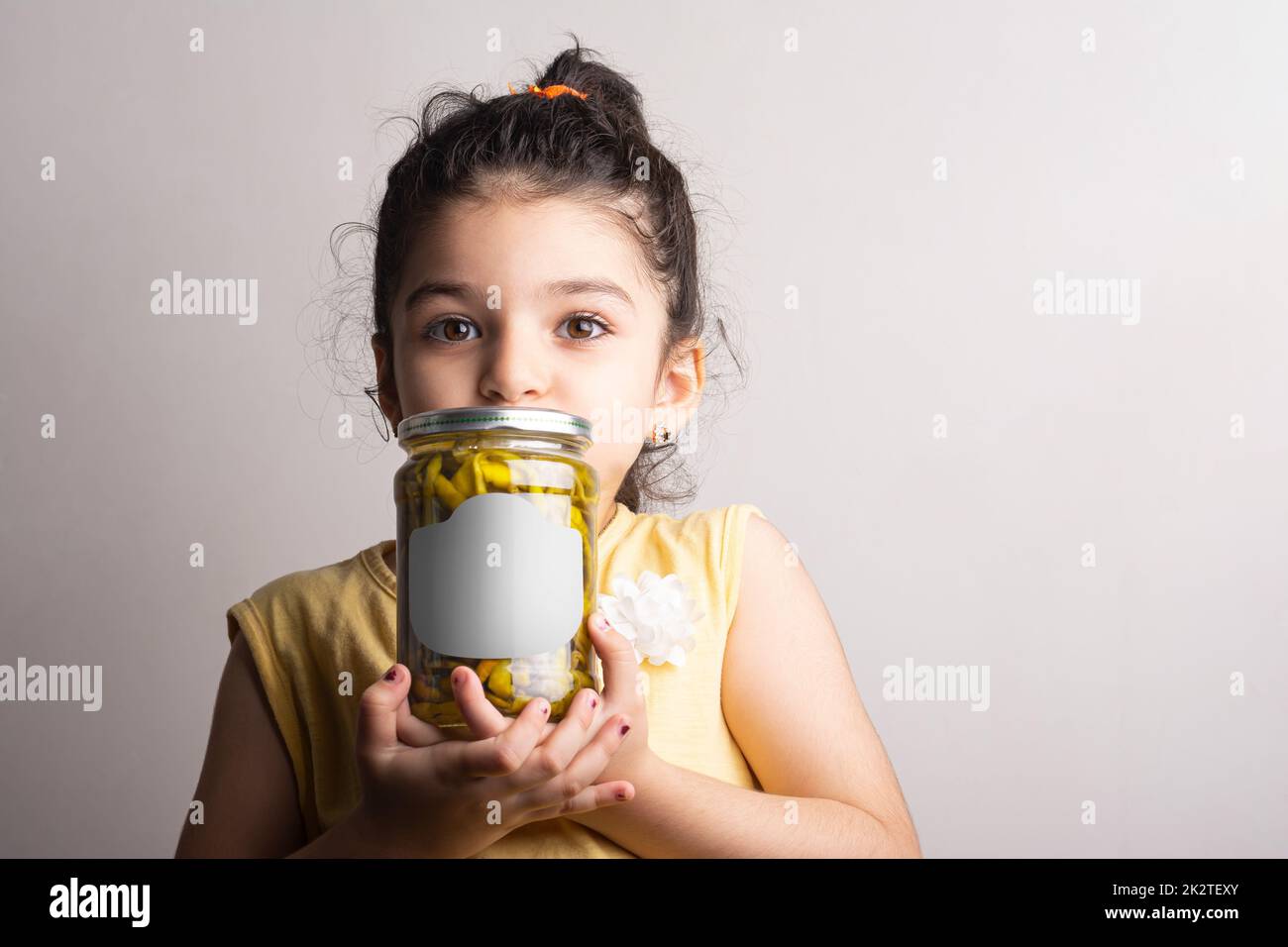 Bambina con un peperone sottaceto conserva a mani mock-up serie 450 Foto Stock