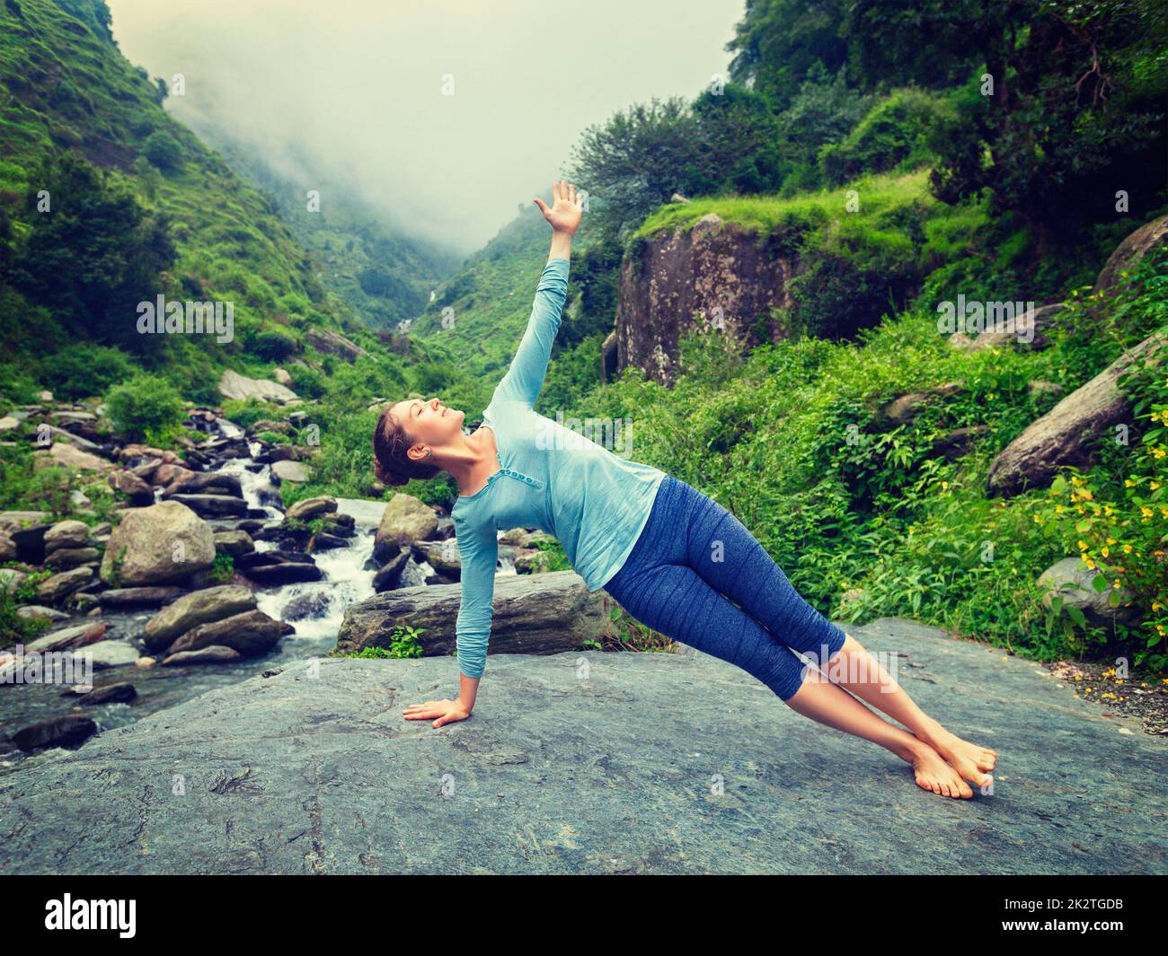 Donna fare yoga asana Vasisthasana - lato plank pongono all'aperto Foto Stock