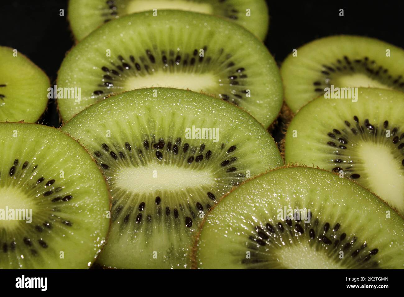 Primo piano di fette di kiwi su sfondo nero. Fondo di frutta. Foto Stock