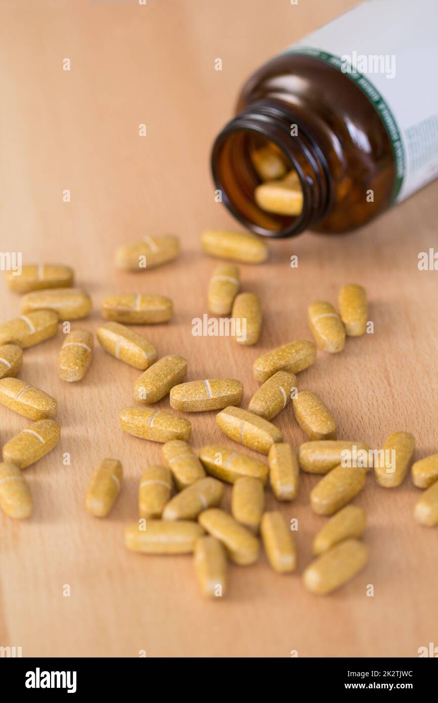 Pillole di supplemento di Vitamina versato da una bottiglia Foto Stock