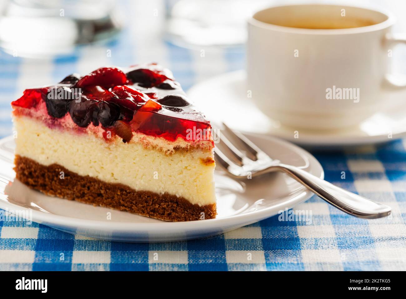 La torta su piastra con forcella e la tazza di caffè Foto Stock