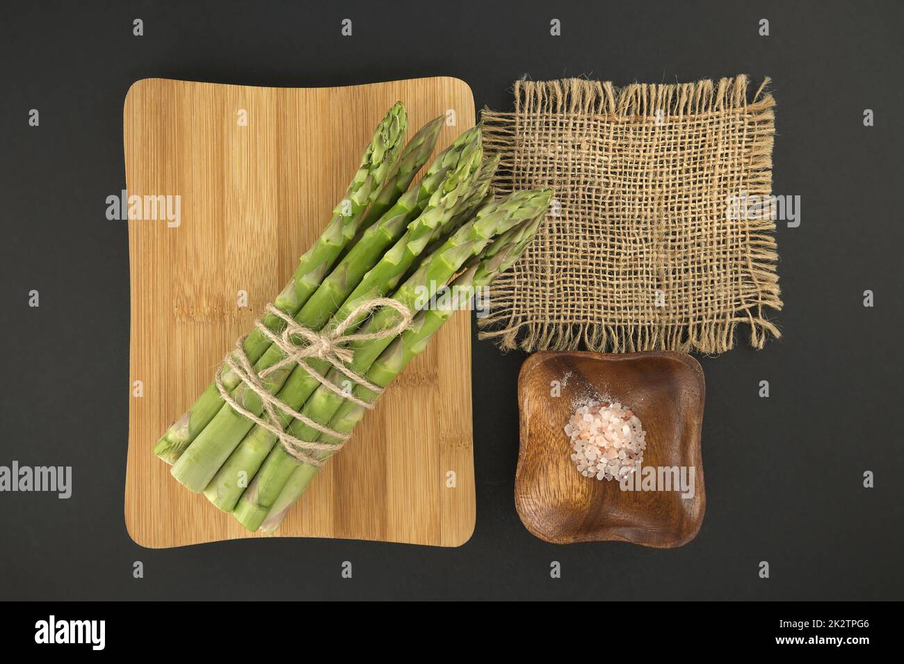 Mazzo di asparagi verdi sul tagliere nero Foto Stock