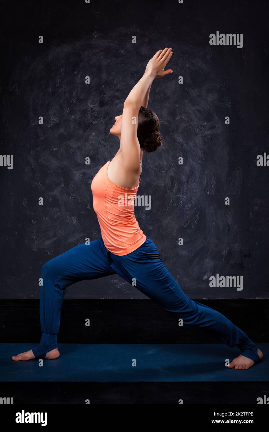 La donna le pratiche yoga asana utthita Virabhadras Foto Stock