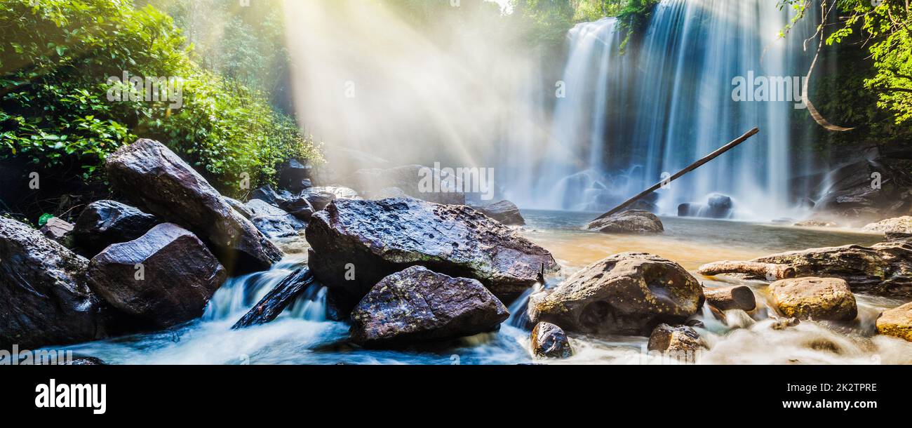 Cascata tropicale nella giungla con raggi solari Foto Stock