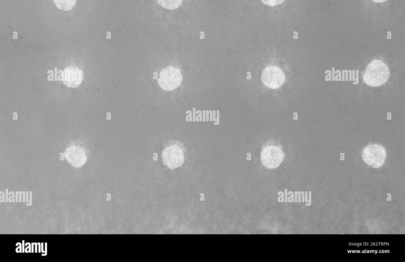 Sfondo bianco e nero astratto in carta monocromatica con piccoli fori rotondi disposti in fila Foto Stock