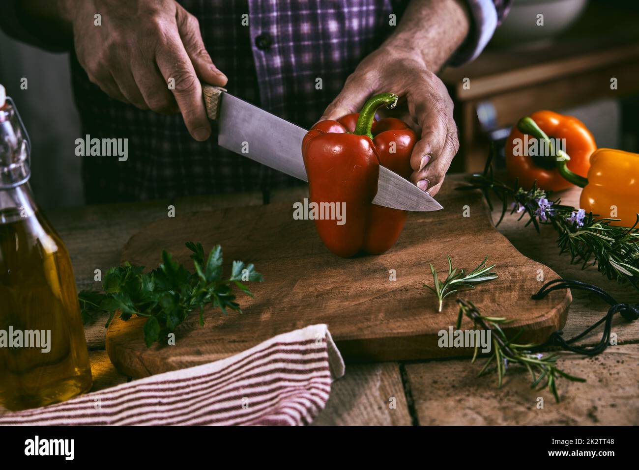Durante la preparazione della cena, ritagliare il peperone senza volto dello chef Foto Stock
