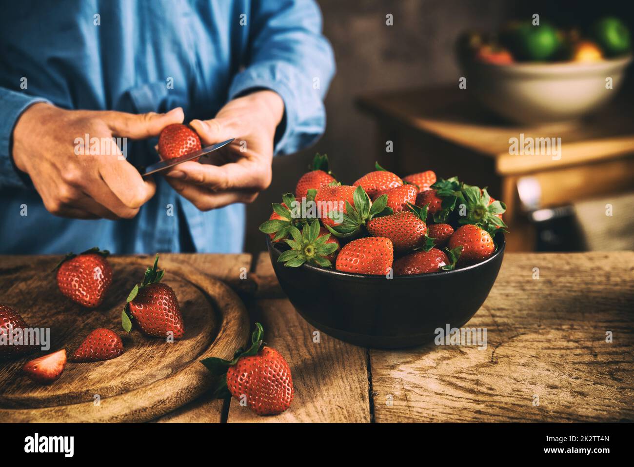 Coltivatore che taglia fragole dolci fresche a tavola Foto Stock