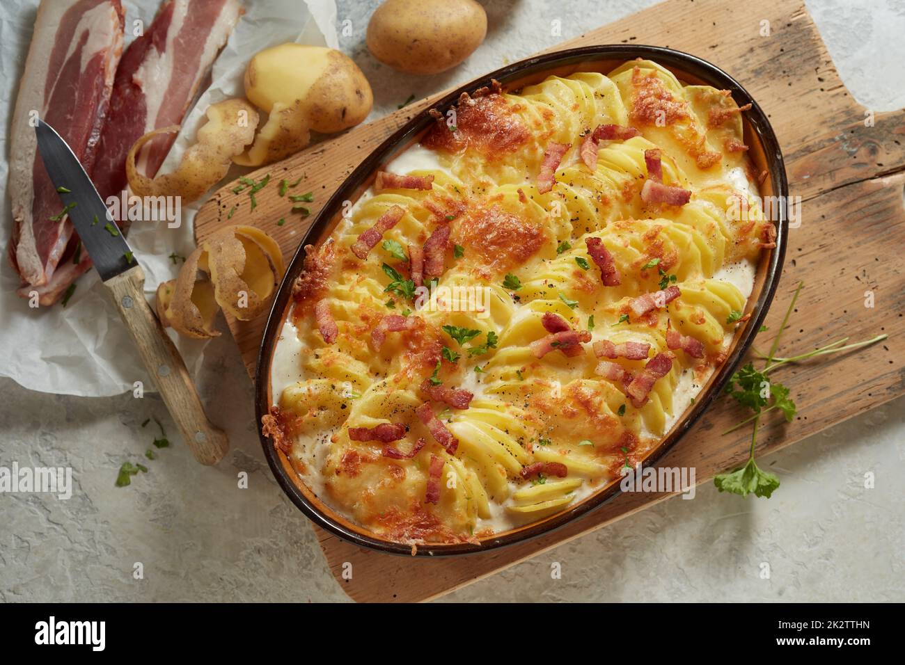 Delizioso piatto fatto in casa con patate e formaggio decorato con pancetta Foto Stock