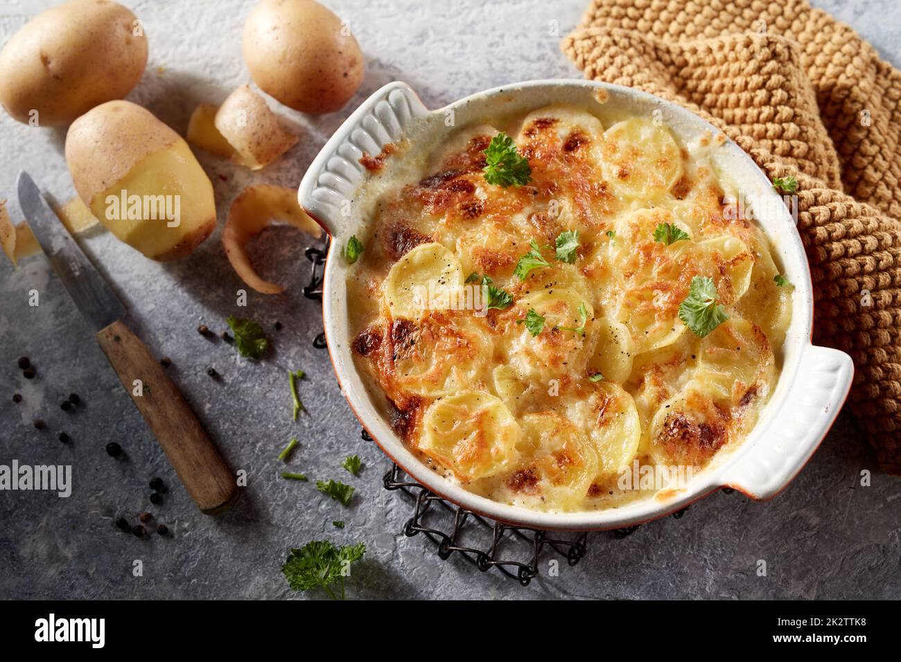 Deliziose patate al gratin calde con erbe in un piatto di ceramica Foto Stock