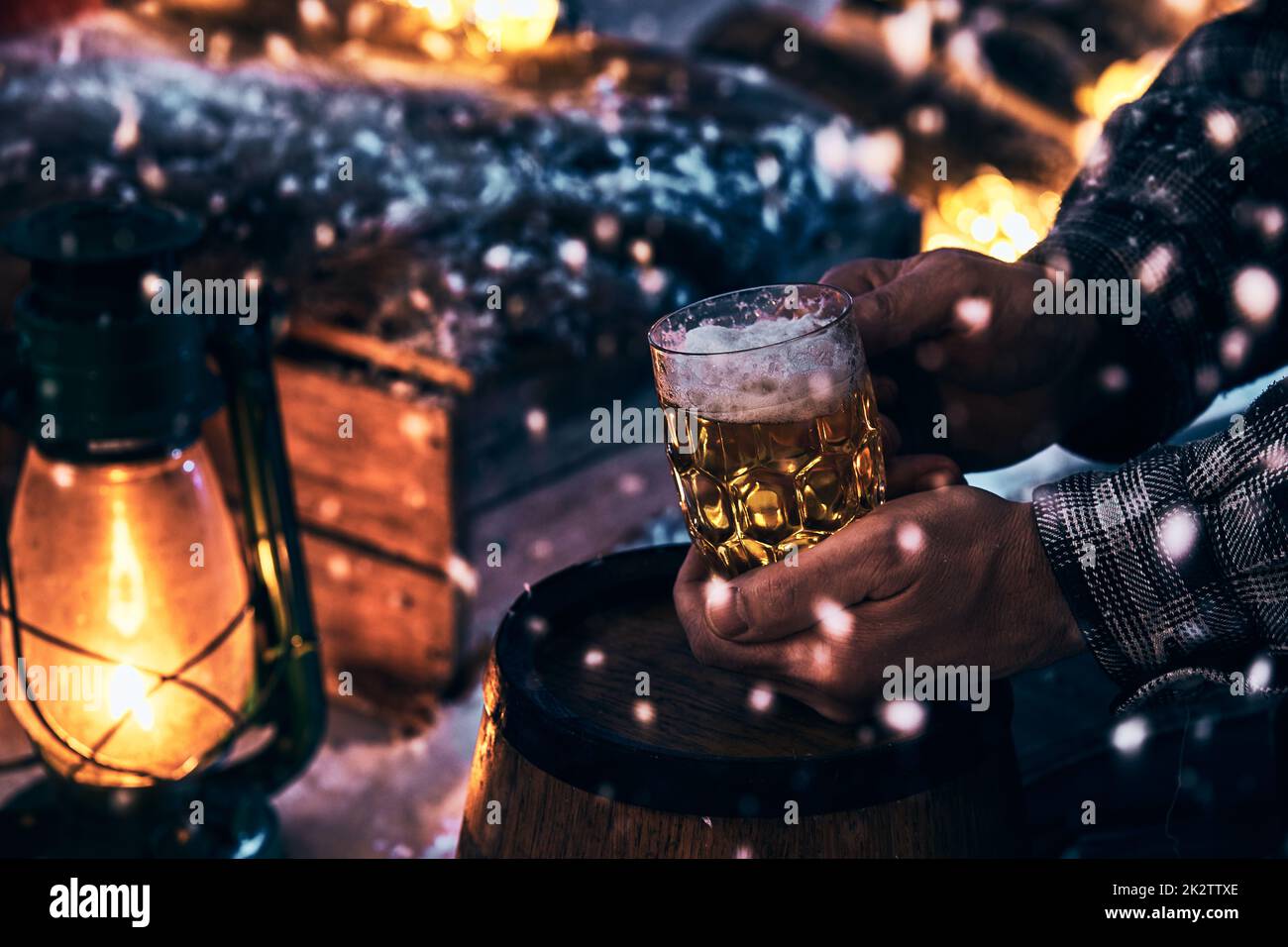 Uomo con un bicchiere di birra nella notte d'inverno Foto Stock