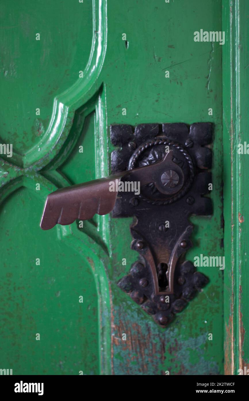 detai maniglie porta in una porta storica in legno verde Foto Stock