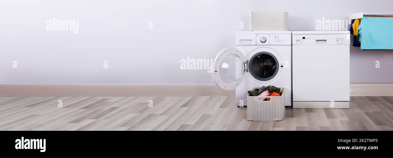 Svuotare la macchina di lavaggio con il mucchio di vestiti sporchi Foto Stock