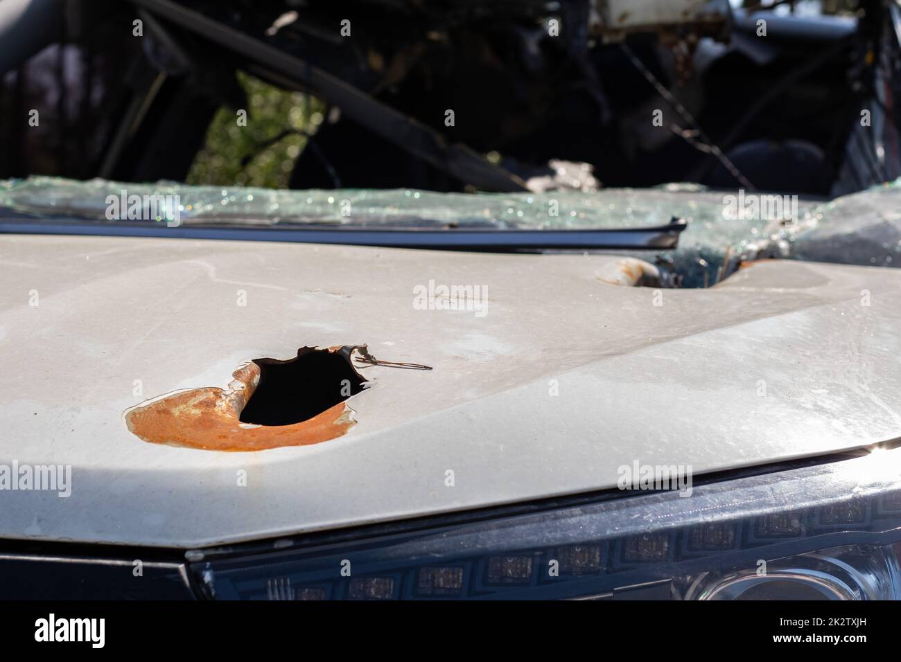 Auto piena di proiettili. Guerra della Russia contro l'Ucraina. Un'auto di civili sparata dall'esercito russo durante l'evacuazione di donne e bambini. Tracce di pallottole e frammenti di conchiglie. Foto Stock