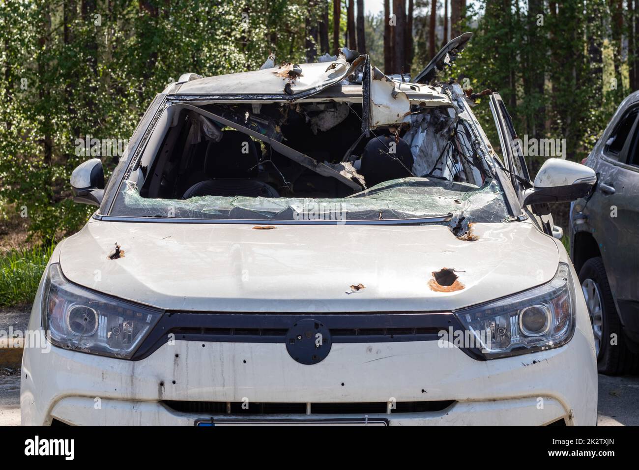 Una macchina di civili sparata dagli invasori durante la guerra in Ucraina. Incidente stradale o incidente. Buchi di shrapnel corpo della vettura. Atrocità dell'esercito russo. Ucraina, Irpen - 12 maggio 2022. Foto Stock