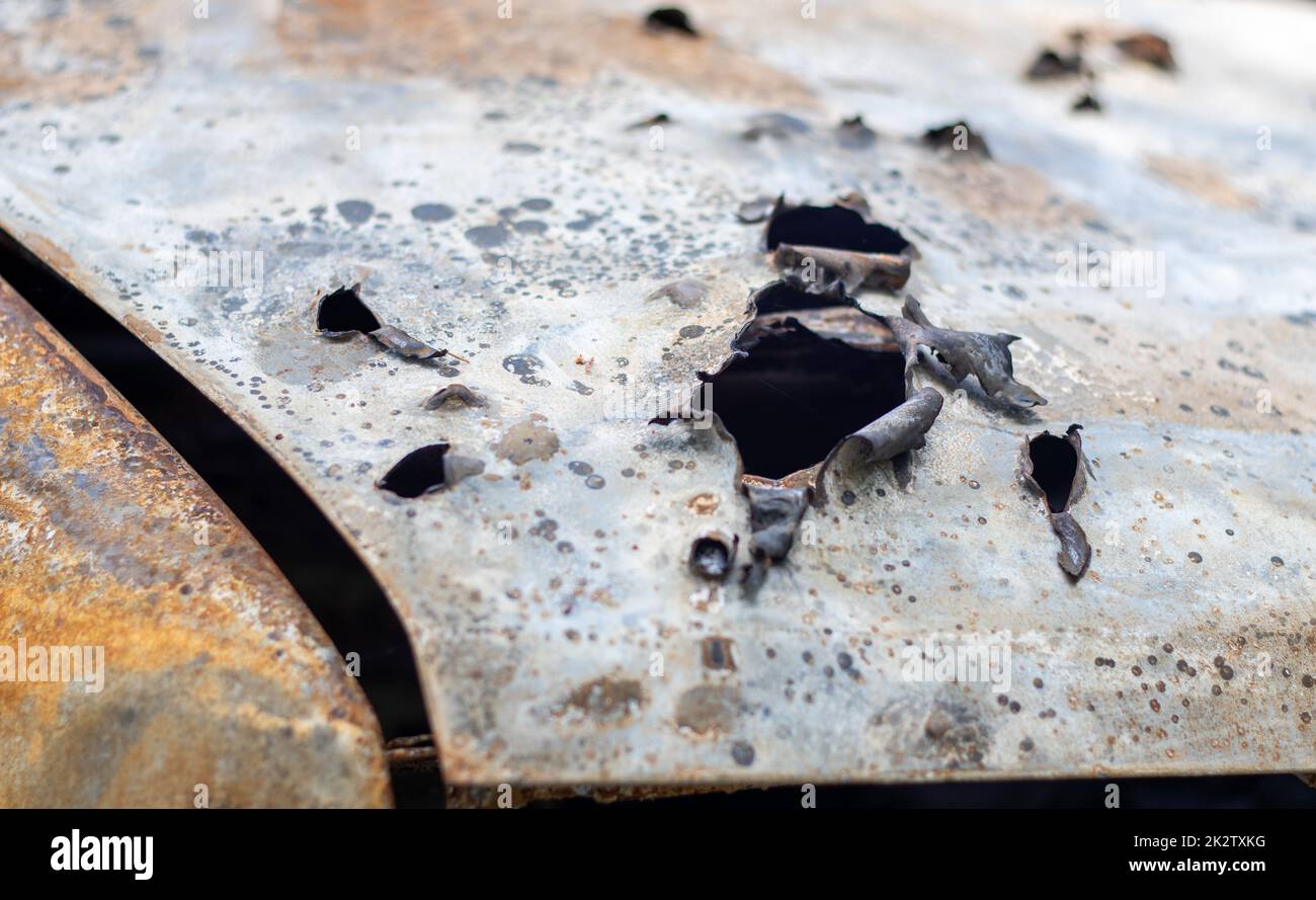 Carrozzeria bruciata piena di proiettili. La guerra della Russia contro l'Ucraina. Sparato dalla macchina militare russa di civili durante l'evacuazione. Tracce di pallottole e frammenti di conchiglie. Foto Stock