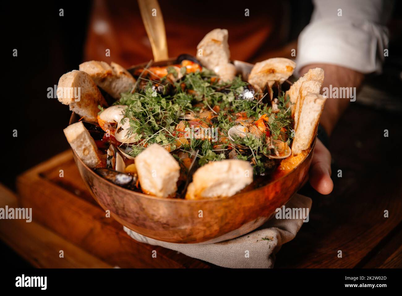Squisita zuppa di pesce decorata con pane affettato servito in una ciotola originale Foto Stock