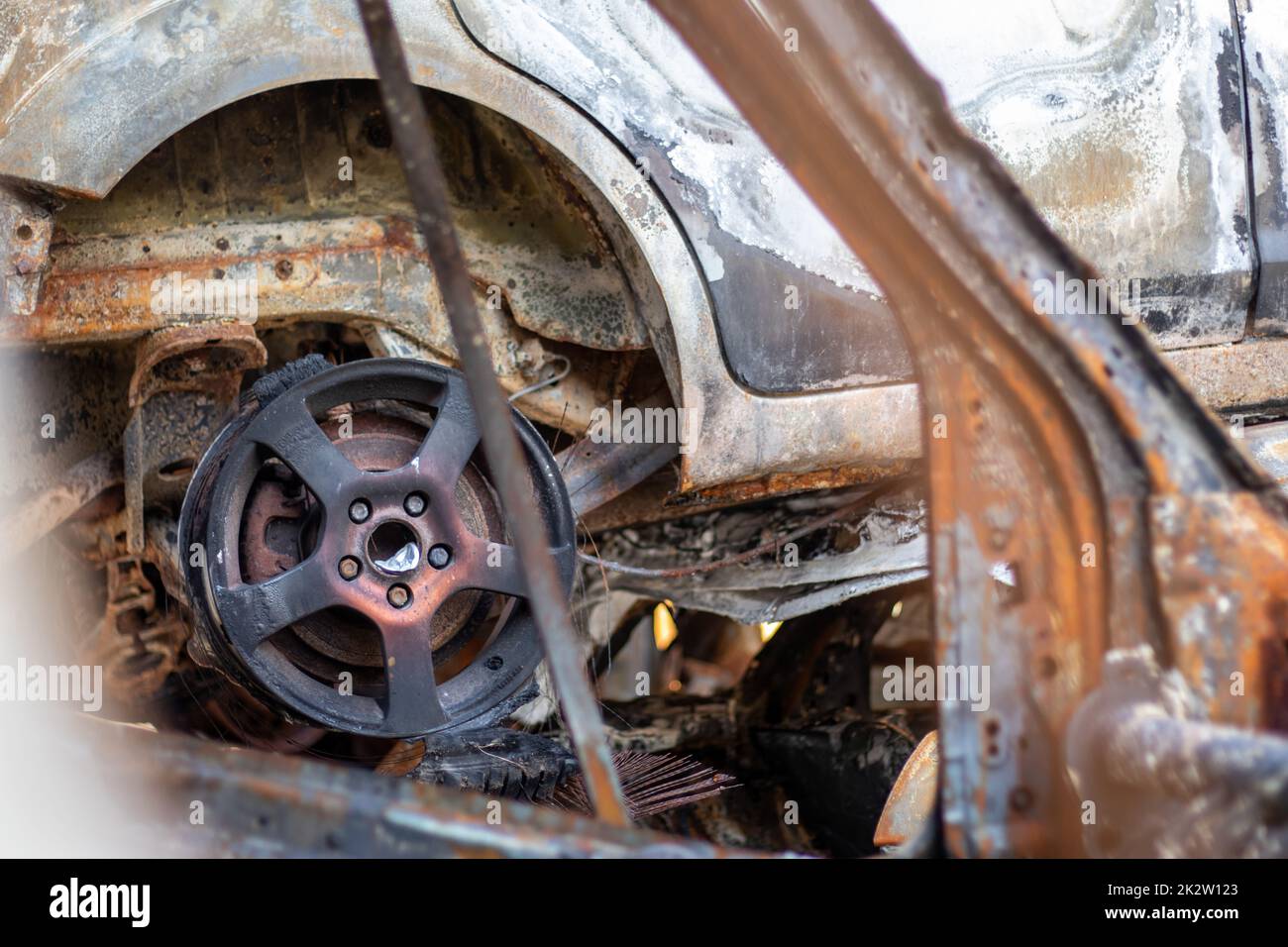 Automobili dopo il fuoco. Ferro parti di un'automobile bruciata. Auto bruciate abbandonate sul lato di una tranquilla campagna. Esplosione, il risultato di un incendio. Concetto di assicurazione auto. Guerra della Russia contro l'Ucraina. Foto Stock