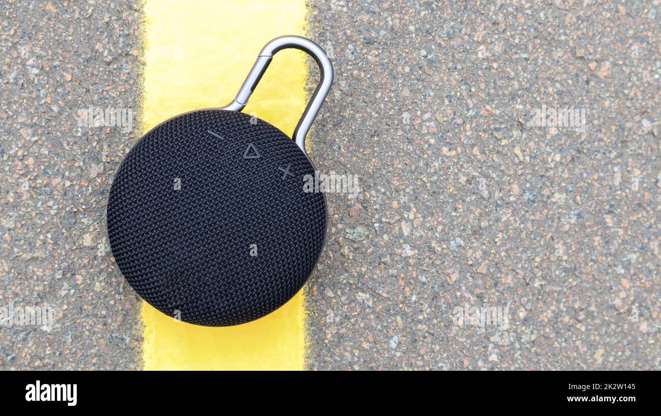 Altoparlante Bluetooth nero rotondo impermeabile con moschettone. Concetto di musica e audio digitale. Mini, adatto per viaggi. Foto Stock
