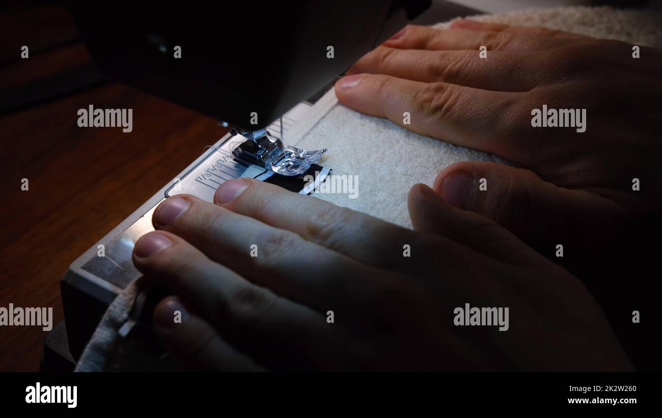 Macchina per cucire ago in movimento. L'ago di primo piano si abbassa rapidamente. Il sarto cucita asciugamano. Foto Stock