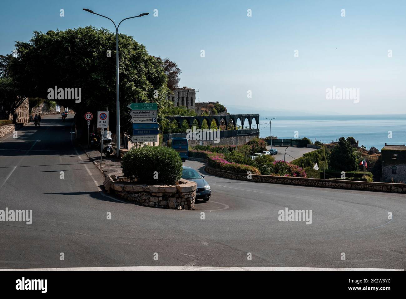 Auto che si muovono su strada in antica città costiera con il cielo sullo sfondo durante l'estate Foto Stock