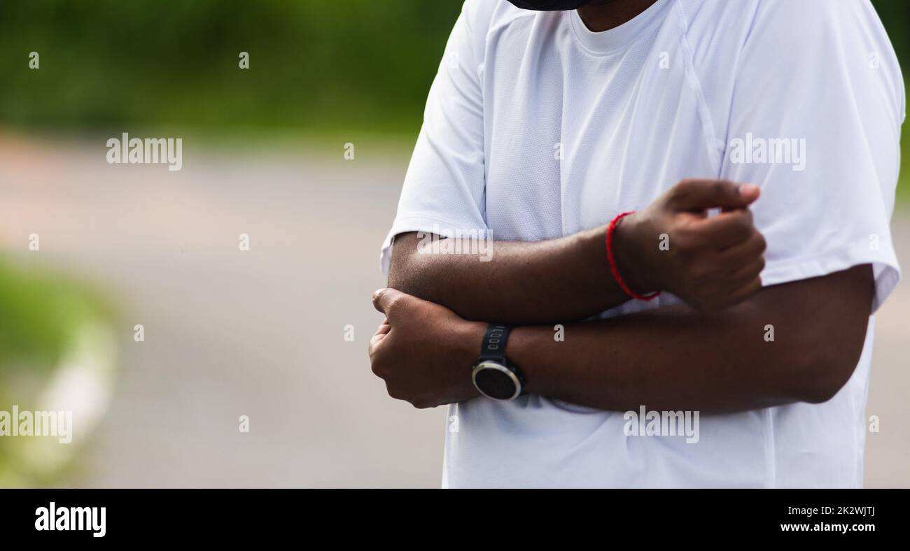 sport corridore uomo nero indossare orologio che ha gomito dolore Foto Stock