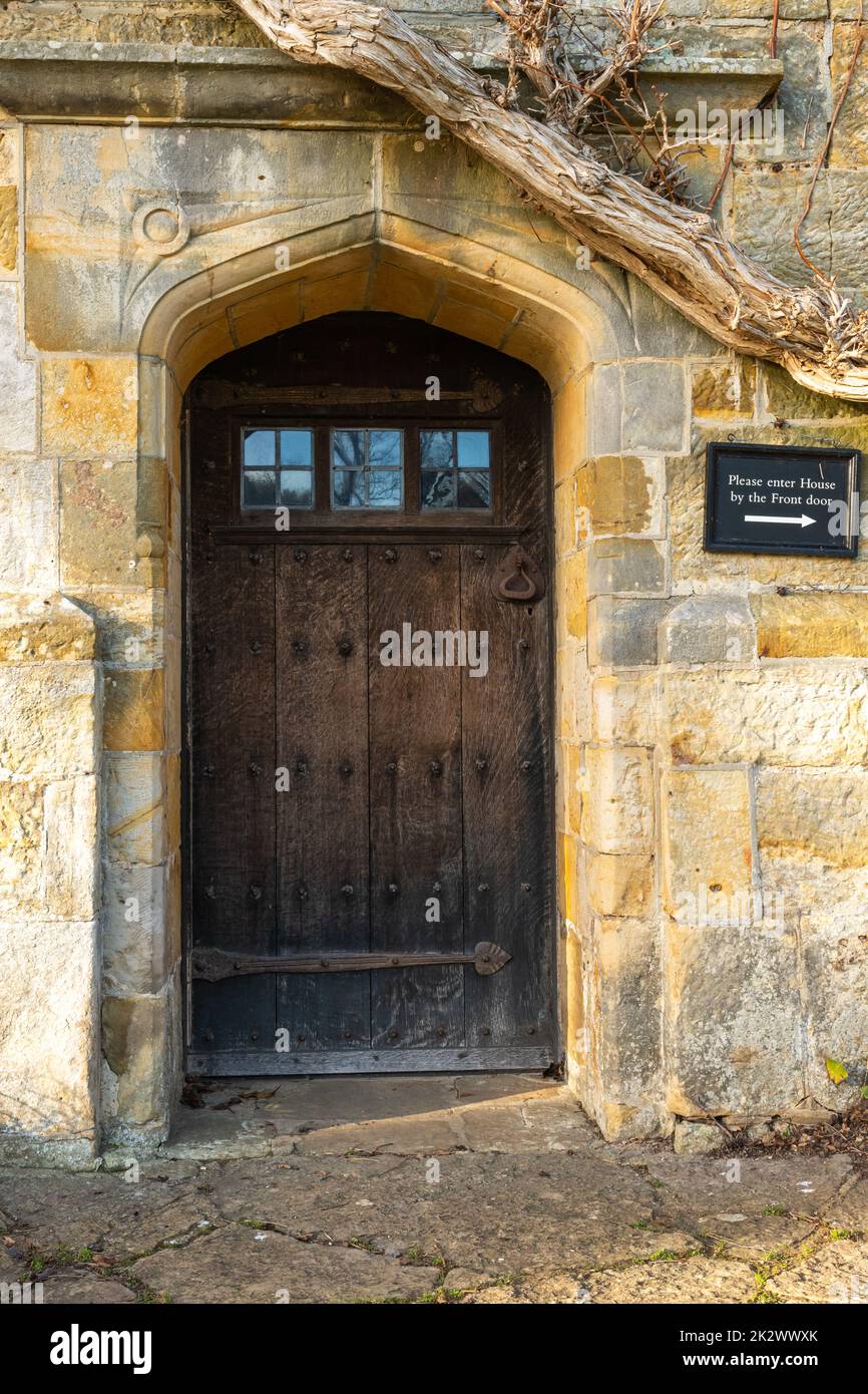 Vecchia porta di quercia con piccole finestre in una porta di pietra, Bateman's, Burwash, East Sussex, Inghilterra Foto Stock