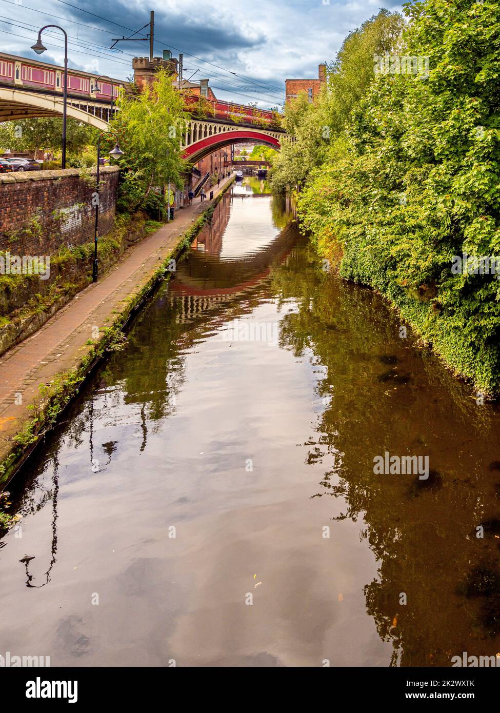 Percorso di traino del canale Rochdale che corre sotto le linee ferroviarie del viadotto Bridgewater nella zona di Castlefield di Manchester. REGNO UNITO. Foto Stock