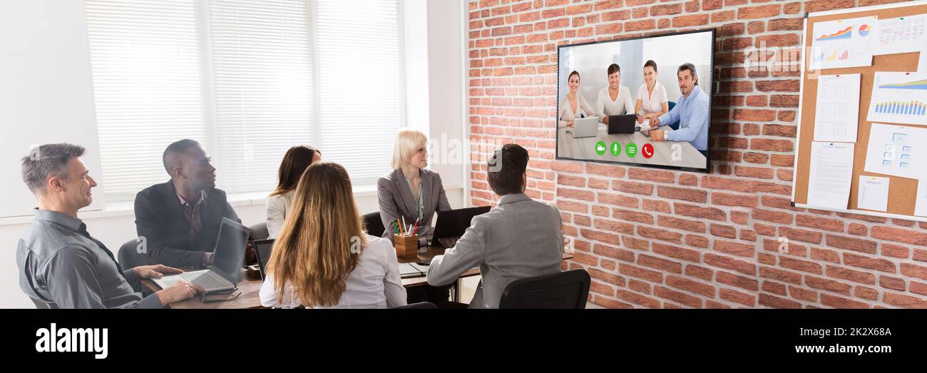 Un gruppo di imprenditori aventi Video conferenza nella sala riunioni Foto Stock