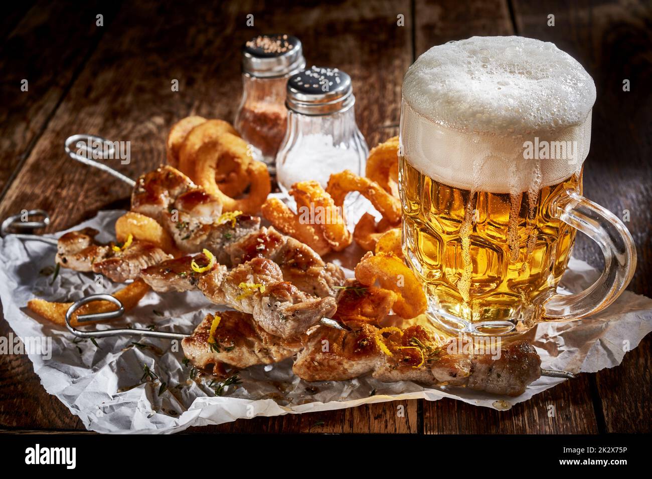 Bicchiere di birra fredda con spuntini sul tavolo Foto Stock