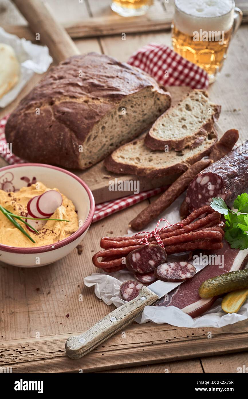 Deliziose salsicce vicino all'hummus e al pane Foto Stock