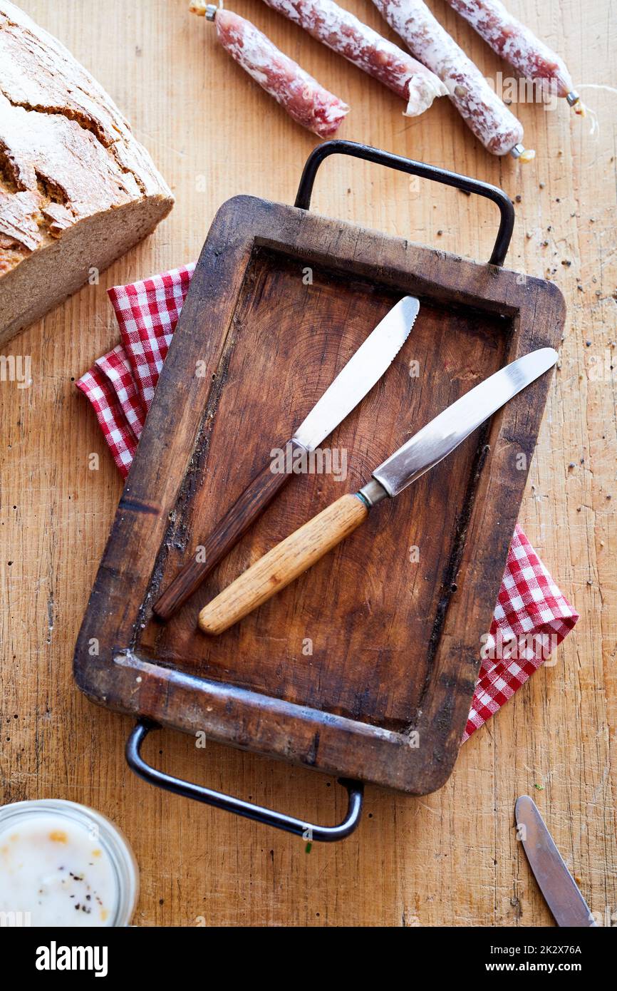 Coltelli della tavola su vassoio di legno Foto Stock